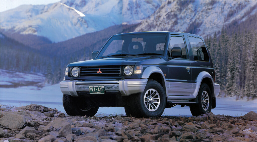 三菱パジェロ・メタルトップ・ワイドXR-II。2代目パジェロは、1991年1月に登場。ラインアップはショートとロングの2シリーズ。ショートはメタルトップとJトップ（キャンバストップ）、ロングにはミドルルーフとキックアップルーフを用意し、３ナンバー仕様（全幅1785mm）と5ナンバー規格（同1695mm）を設定した。２代目の特徴は、一段と進化したオールラウンド性能。4種の駆動モードが選べる「スーパーセレクト4WD」を採用。3リッターV6ガソリンと2.5リッター直4ディーゼルターボがパワフルな走りを約束した。カタログでは「本質を、走り続けるもの」と宣言。「パジェロの進化が、4WDの進化」と語りかけた