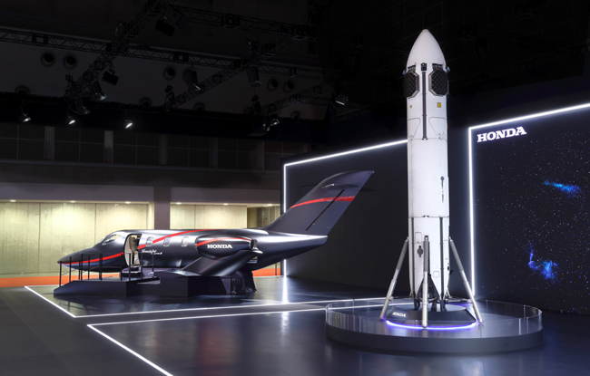 ▲新世代小型ビジネスジェット機「HondaJet Elite Ⅱ」の実物大インテリアモックアップモデル(写真・奥)と、2025年6月に離着陸実験を行ったサステナブルロケットの実際の実験機(同・手前)を出展