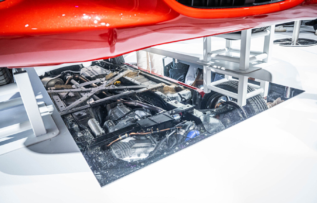 ▲ブースでは「K-OPENランニングプロト」も展示。軽規格のエンジンは従来コペンの横置きからスラント縦置きに変更し、ここに新開発のトランスミッションとリアへと伸びるドライブシャフト、後輪左右に駆動を伝えるリアデファレンシャルを組み込む