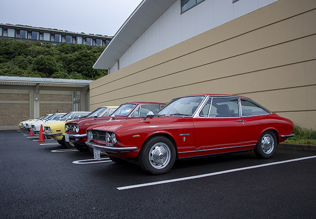 いすゞ117クーペは、G・ジウジアーロがカロッツェリア・ギア在籍時に造形。国産初の高級スペシャルティモデルとして1968年12月に発売した。昼食会には日本各地からオーナーが参加。手前のモデルは 希少な「ハンドメイド」の電子制御インジェクション仕様