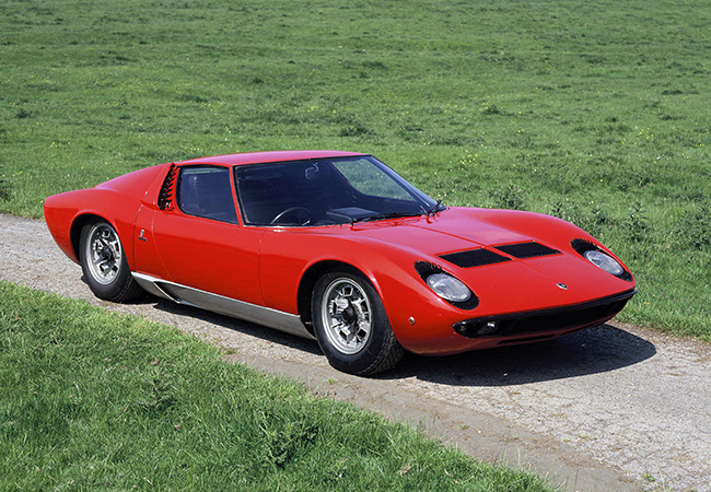 ミウラはランボルギーニ初のミッドシップV12スポーツとして1966年3月のジュネーブ・ショーでワールドプレミアを飾り、1973年まで759台を生産。開発責任&シャシー設計はジャンパオロ・ダラーラ。彼はジオット・ビッザリーニが手がけた4リッター・V12ユニットをキャビン背後に横置き搭載。革新的なMRロードカーを生み出した