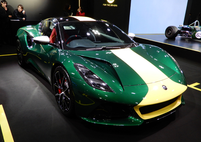 ▲ロータスが東京オートサロン2026にミッドシップスポーツカーのエミーラの特別限定モデル「エミーラ・クラーク エディション」を出展。インディグリーンを現代的に再現した“クラーク・レーシンググリーン”のボディカラーに、アイコニックなヘセルイエローのストライプを配する